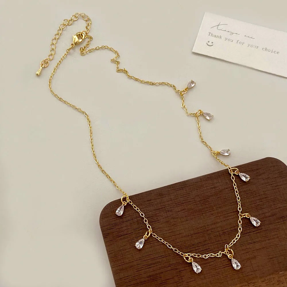 Zircon jewellery set with geometric pendant necklace, matching earrings, and anklet in silver-tone chain