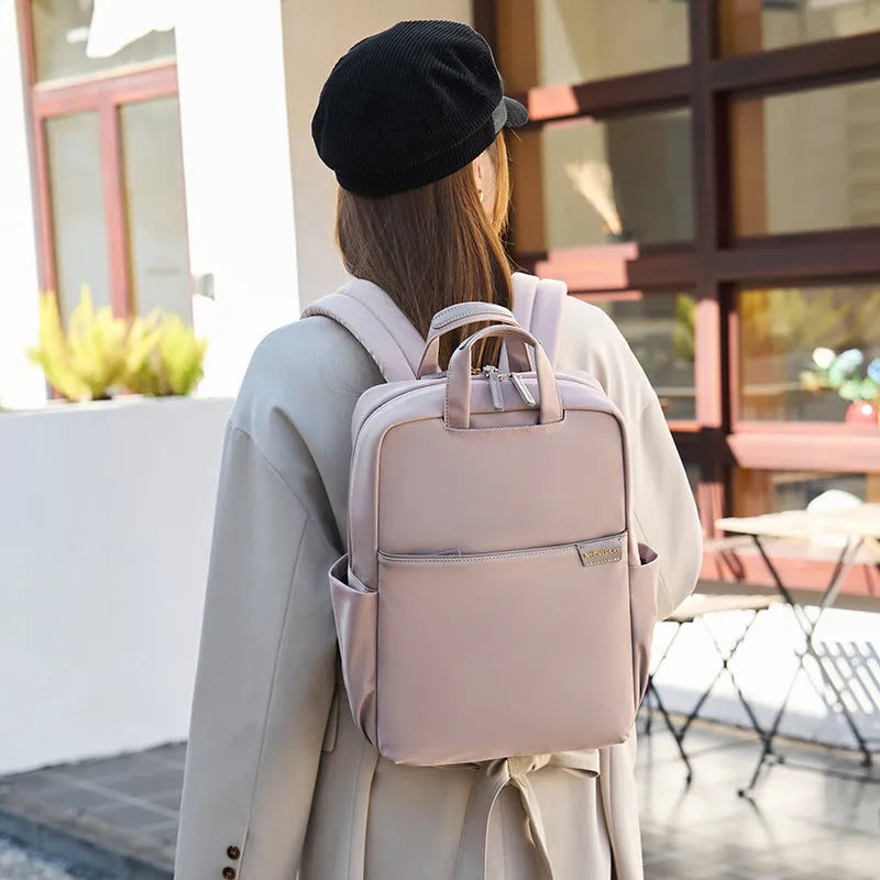 Large canvas women's backpack in apricot colour showing front view with multiple pockets and internal compartments open.
