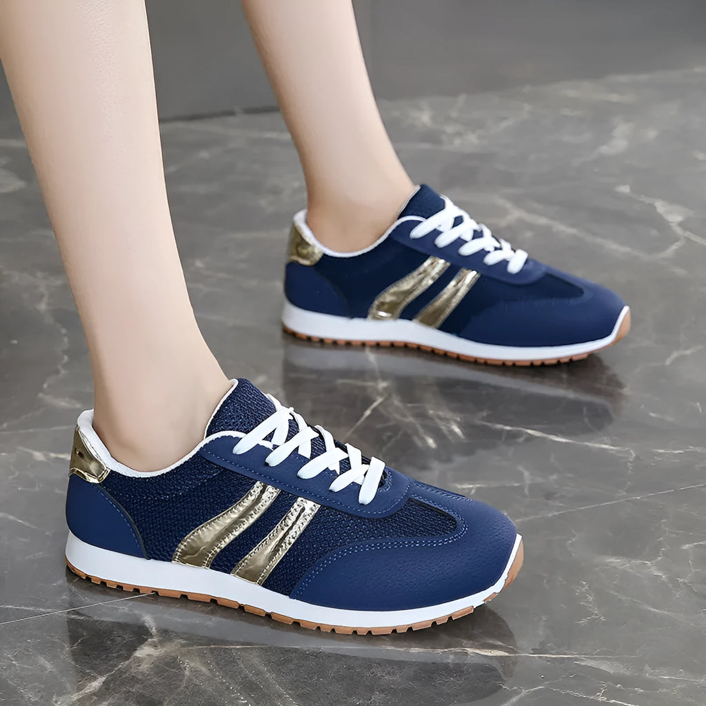 Blue women's casual tennis shoes with a cross shoulder strap and flat rubber sole on a white background.