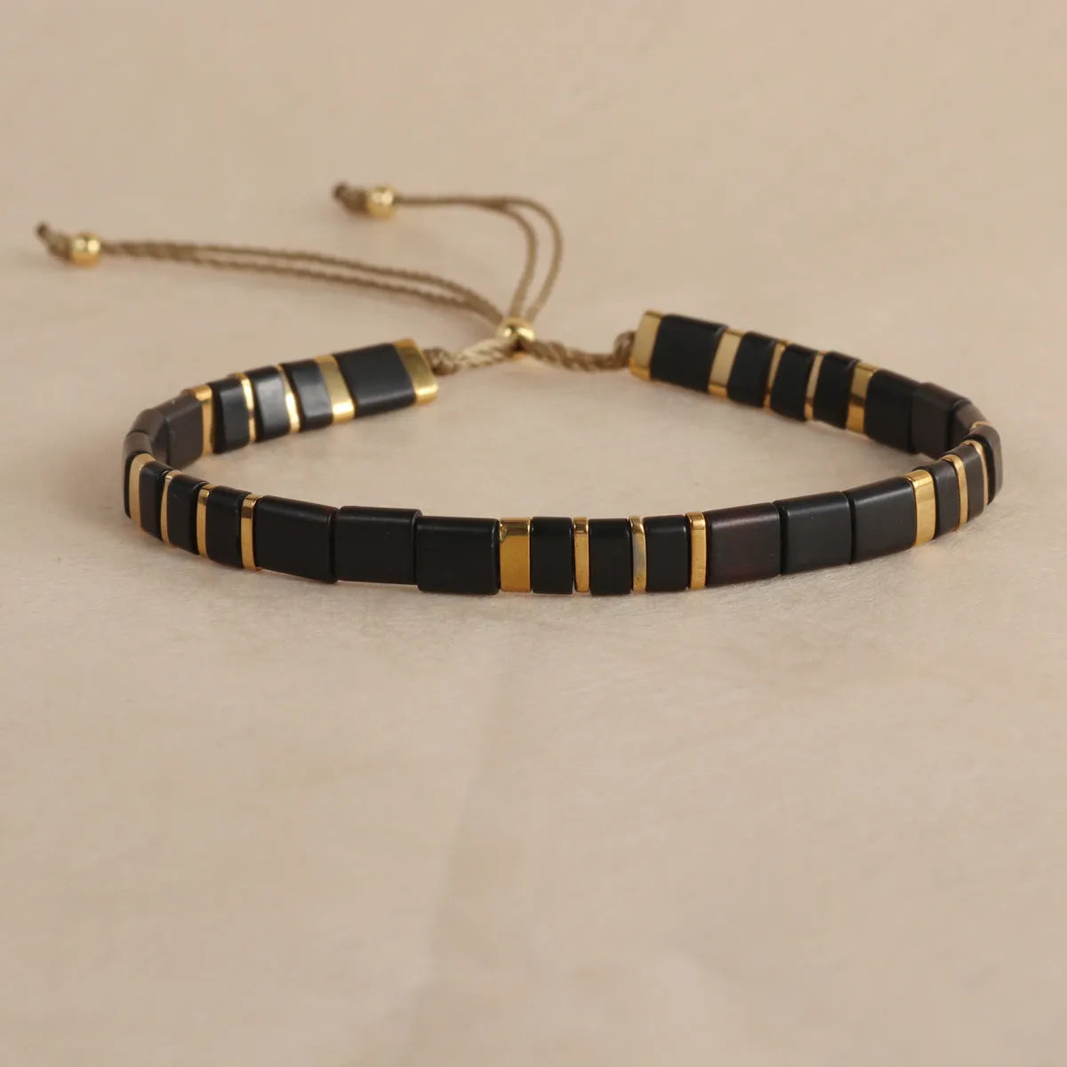 Geometric glass and coloured glaze beaded bracelet in milky white on a wrist.