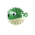 Green fish-shaped dog toy with squeaky bell and treat-dispensing opening