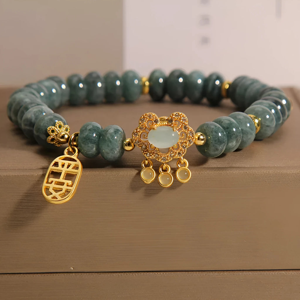 Close-up of a women's bracelet with green emerald jade abacus beads and a silver-toned alloy safety lock clasp.