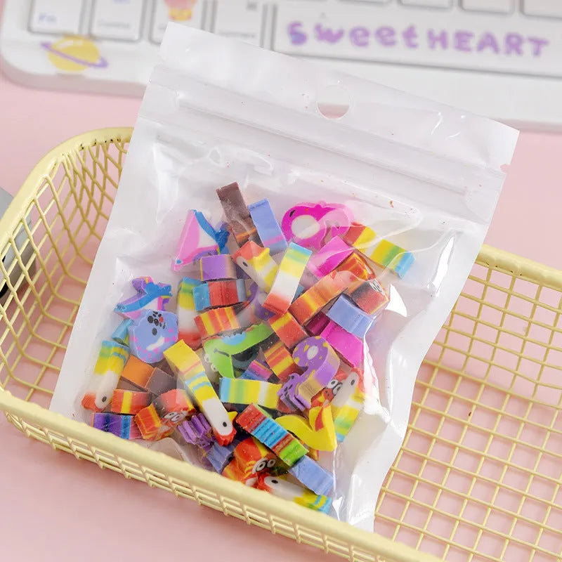 Open pearlescent film bag showing 50 small colourful cartoon fruit-themed rubber erasers.