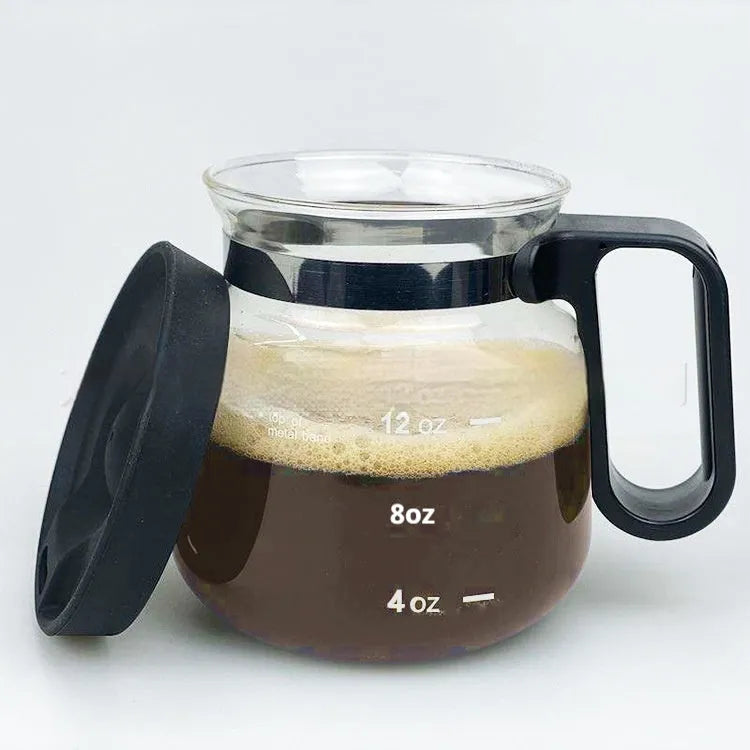 Transparent borosilicate glass coffee maker with a black silicone cover on its lid.