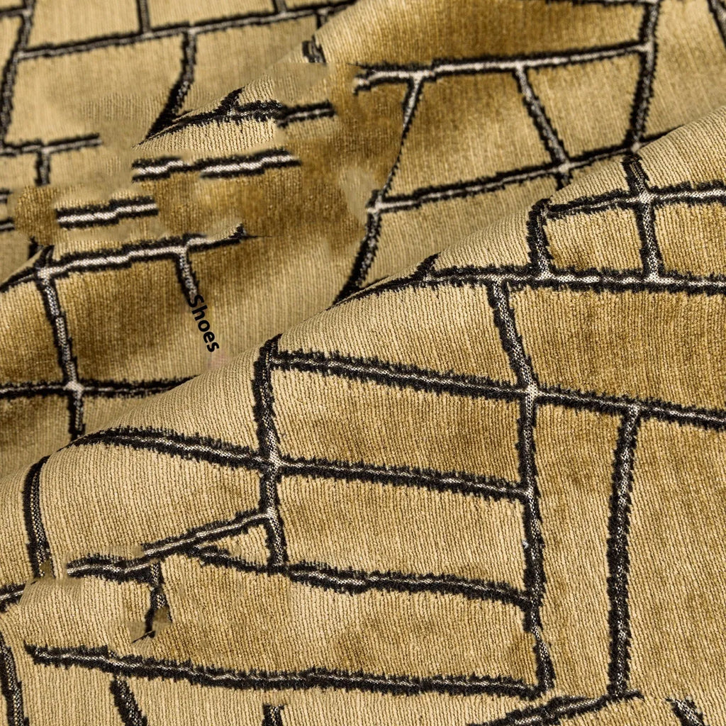 Geometric abstract patterned cushion in local gold colour, shown in square and lumbar sizes on a grey sofa.