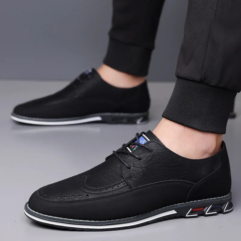 Men's black leather-toe casual shoes with a fabric upper and rubber sole on a plain background.