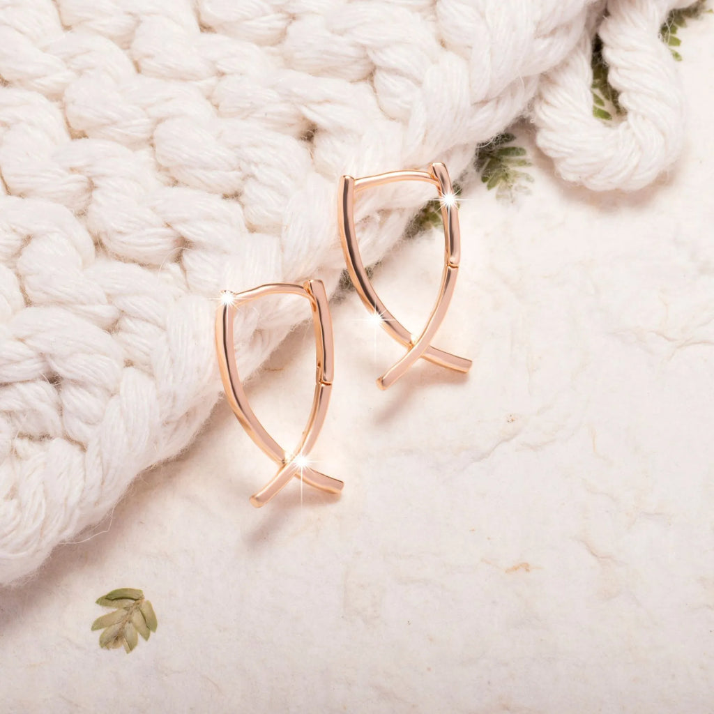 Rose gold cross shaped earrings with copper construction and light luxury aesthetic