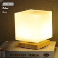 Nordic solid wood USB table lamp in a geometric shape on a wooden surface.