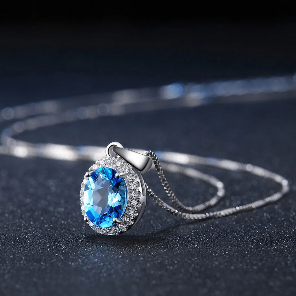 925 sterling silver jewellery set with blue topaz gems in geometric design including earrings, ring, necklace and pendant