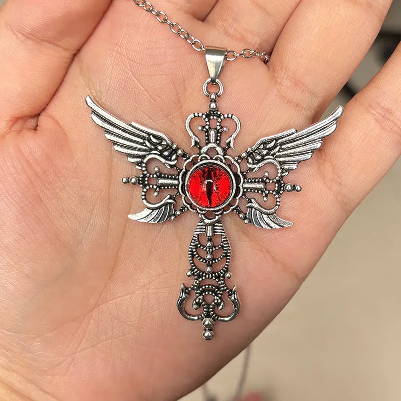 Close-up of a devil wings and cross geometric alloy pendant necklace on a chain.