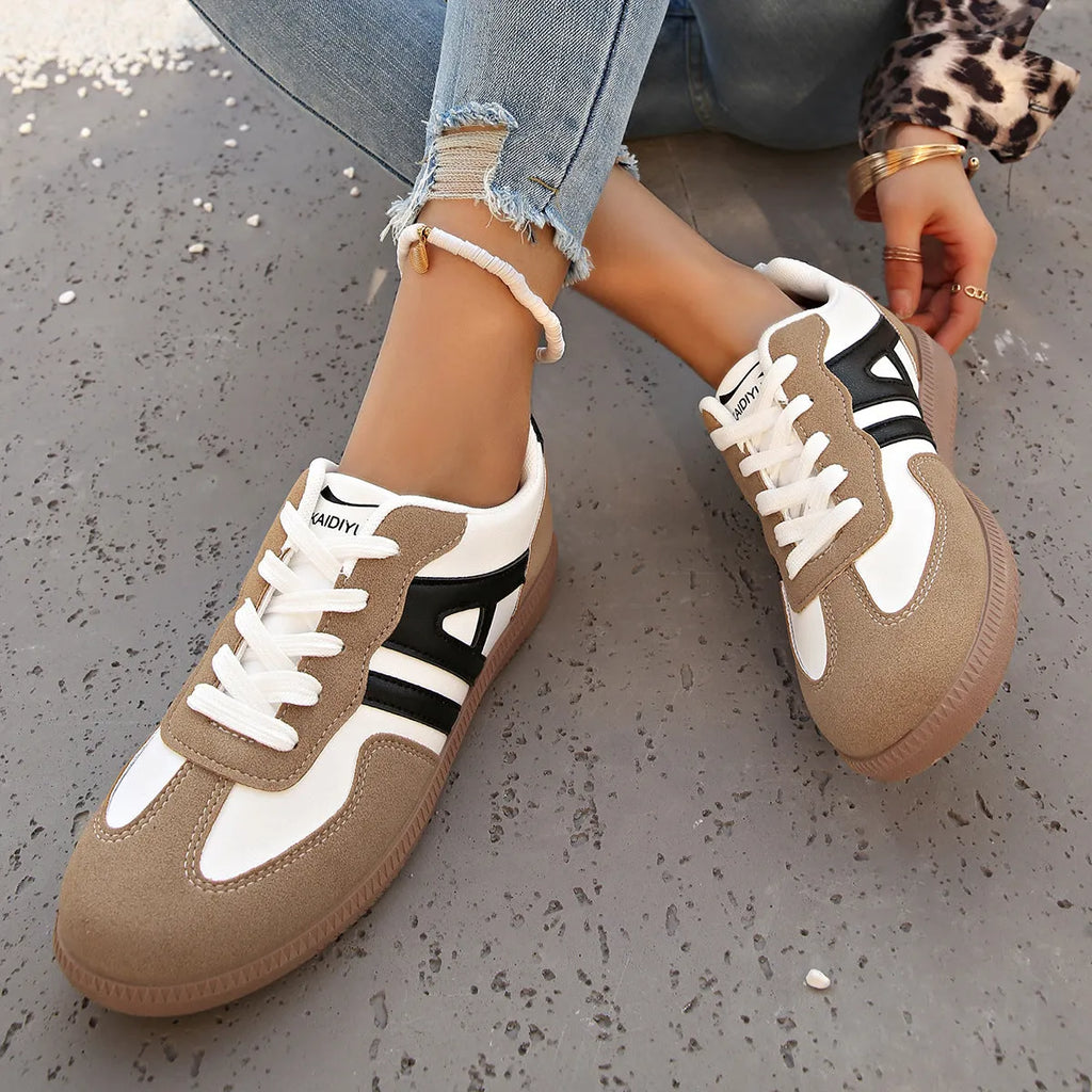 Women's retro style lace-up jogging shoes in grey with a cross strap and low platform heel.