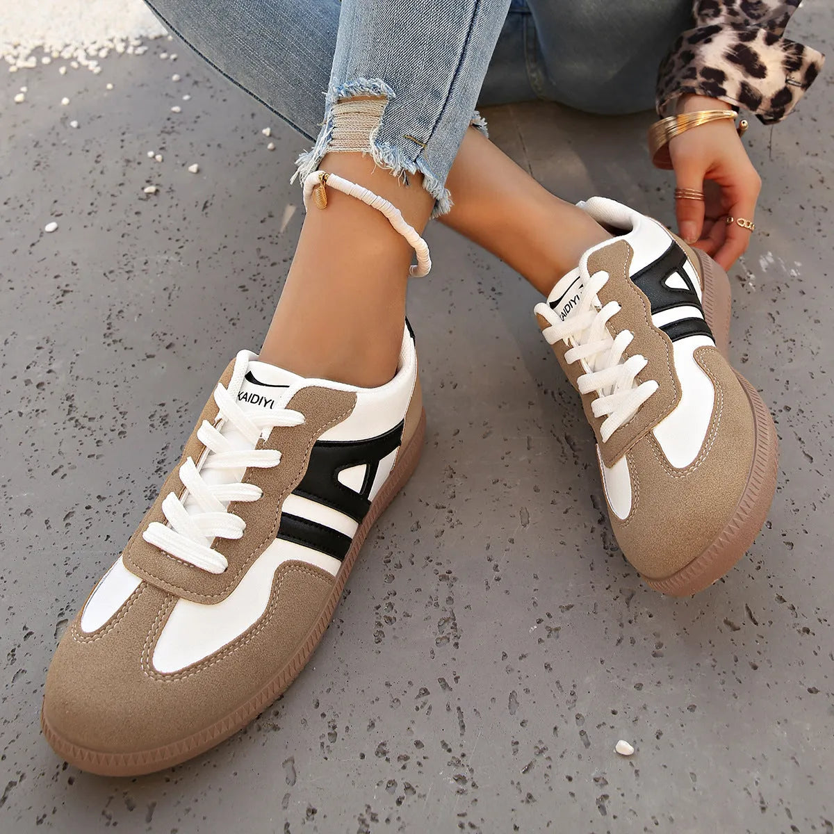 Women's retro style lace-up jogging shoes in grey with a cross strap and low platform heel.