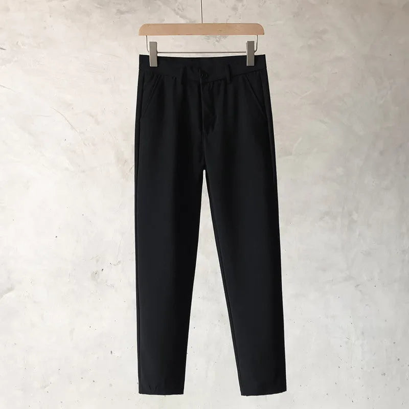 Boys slim straight-leg wool trousers in tapered cut, shown in black, on a hanger.