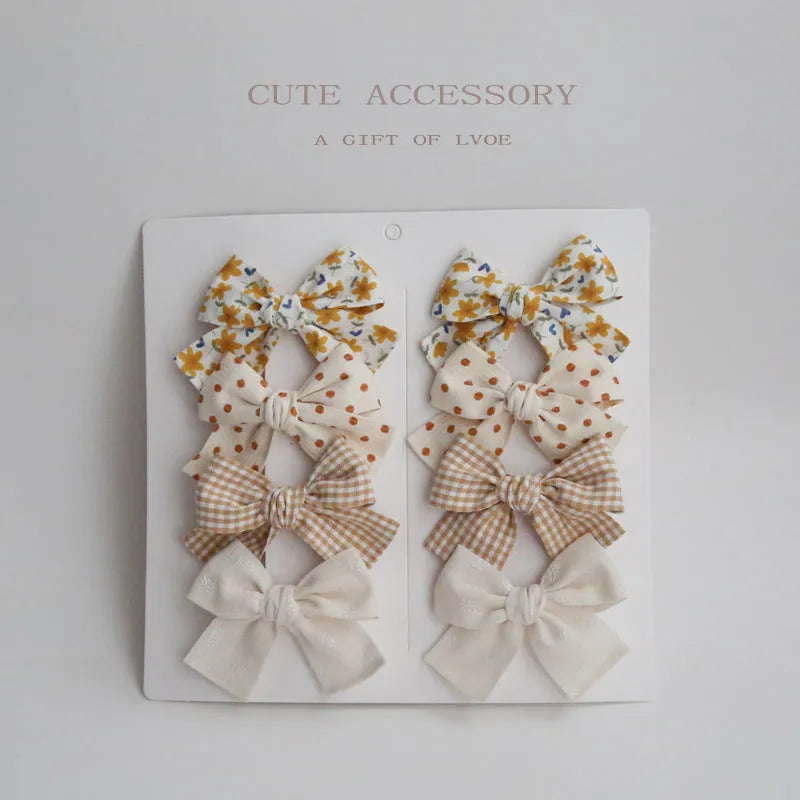 Children's dovetail bow hairclips in eight colour patterns including grid dots and floral designs