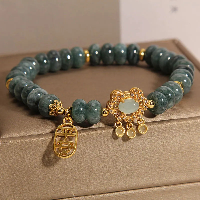 Close-up of a women's bracelet with green emerald jade abacus beads and a silver-toned alloy safety lock clasp.