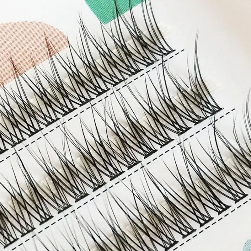 Black V-shaped fairy fishtail false eyelashes with thick segments in varying lengths on a clear tray.