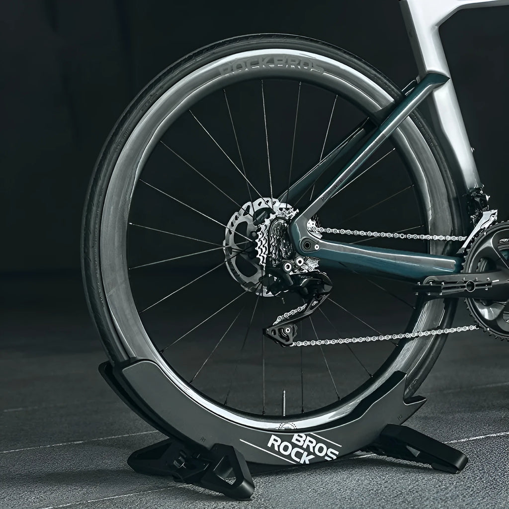Black and green ABS plastic bicycle parking rack holder with fixed wall mounting bracket.