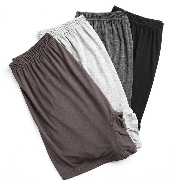 Man holding a pair of solid colour high-waist modal boxer shorts in dark grey.