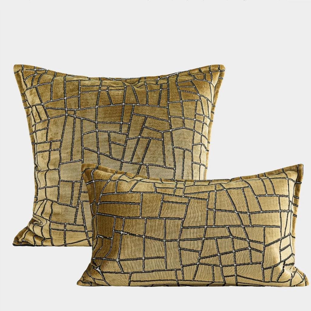 Geometric abstract patterned cushion in local gold colour, shown in square and lumbar sizes on a grey sofa.