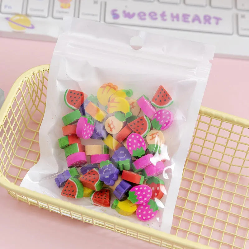 Open pearlescent film bag showing 50 small colourful cartoon fruit-themed rubber erasers.