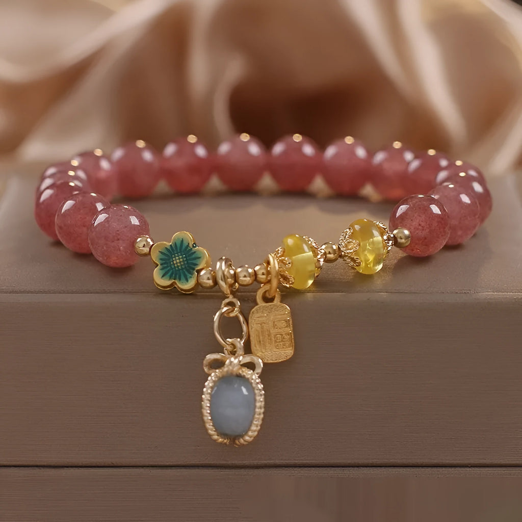 Red strawberry quartz beaded bracelet with silver-toned alloy charms and clear rhinestone details.