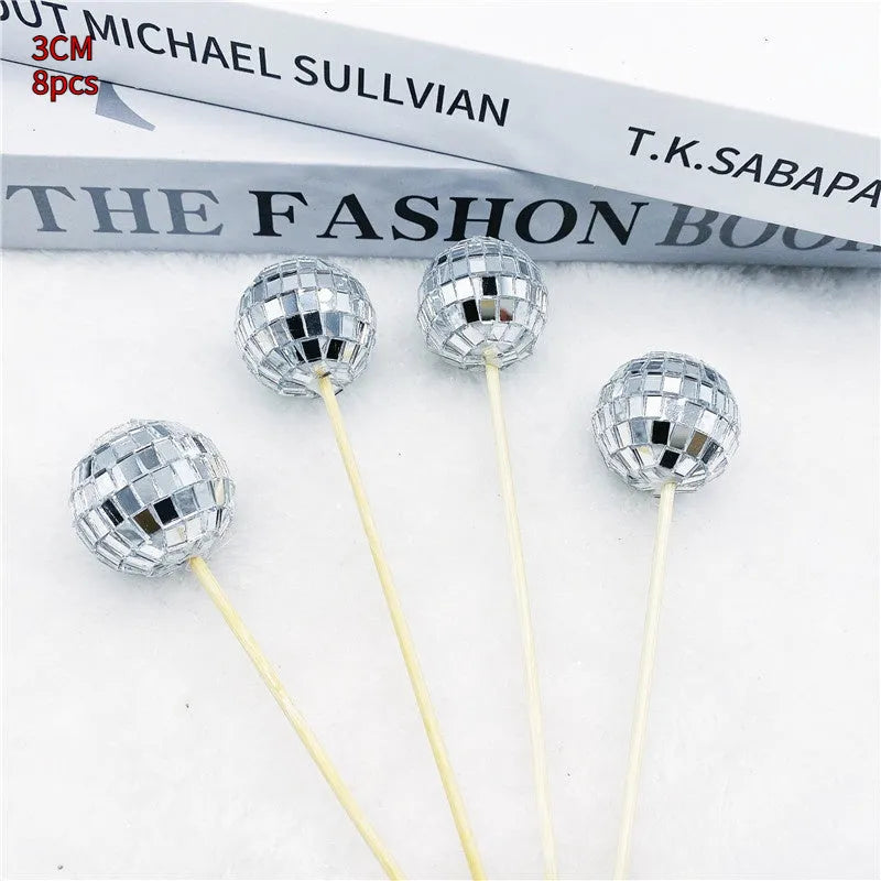 Glass disco ball cake decoration with wooden stick on a birthday cake