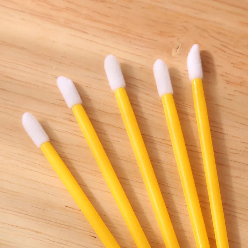 Pack of disposable lip brushes with flocked heads and coloured handles, shown in quantities from 200 to 500 pieces.