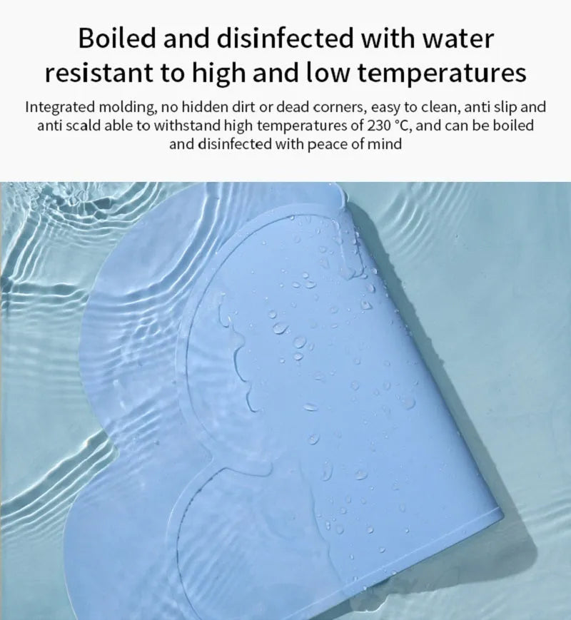 Blue silicone pet feeding mat with cat head shape under food and water bowls.