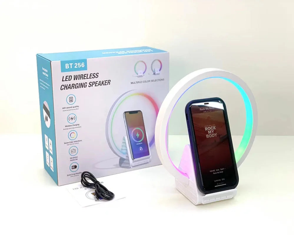 White smart Bluetooth speaker with wireless charging pad and ambient light on top.