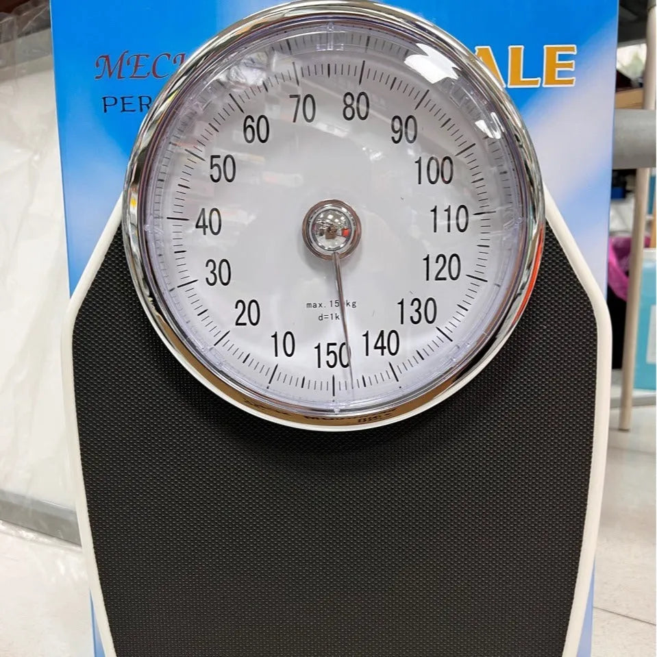 Black mechanical bathroom weight scale with large analogue dial on a simple platform.