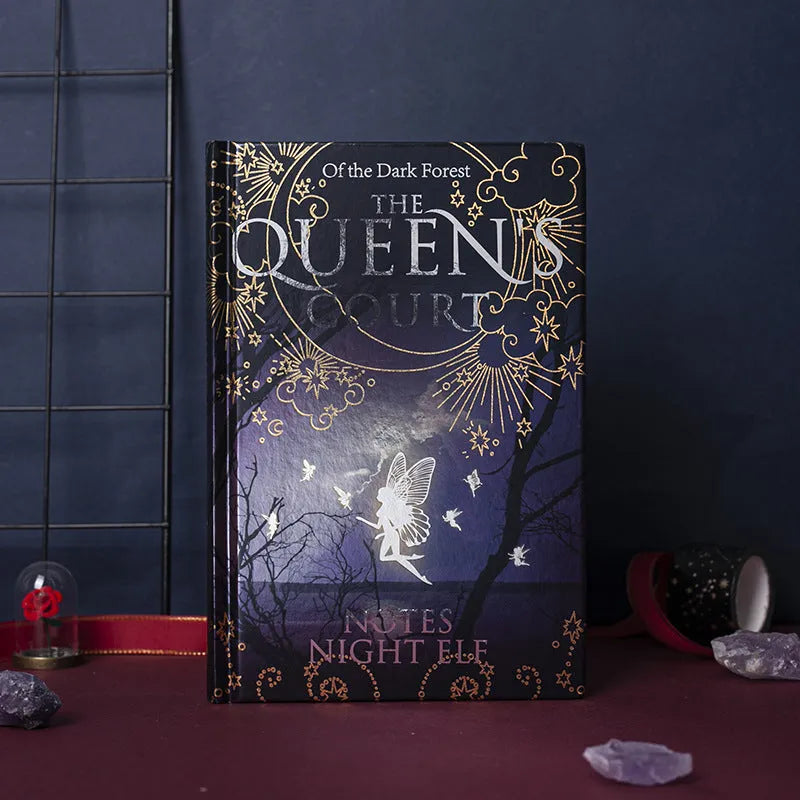 Blue luminous hardcover A5 notebook lying open on a desk, showing full-colour illustrated pages.