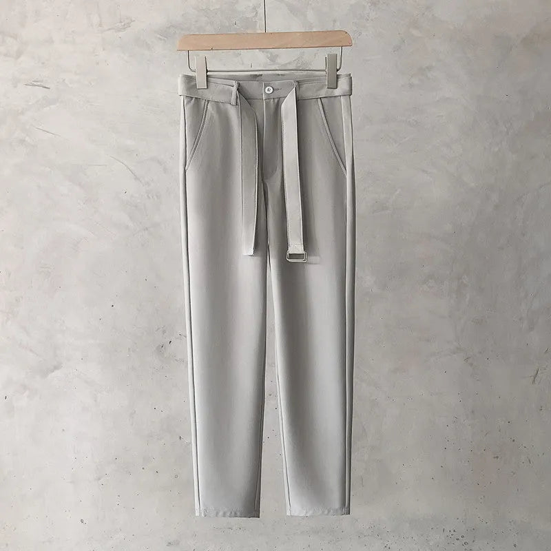 Boys slim straight-leg wool trousers in tapered cut, shown in black, on a hanger.