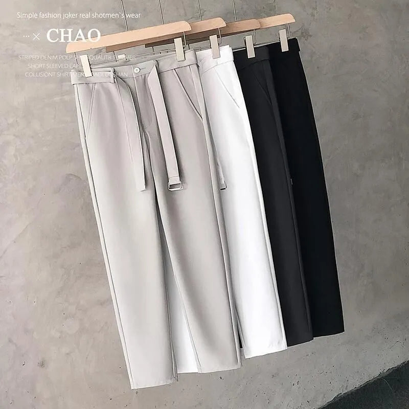 Boys slim straight-leg wool trousers in tapered cut, shown in black, on a hanger.