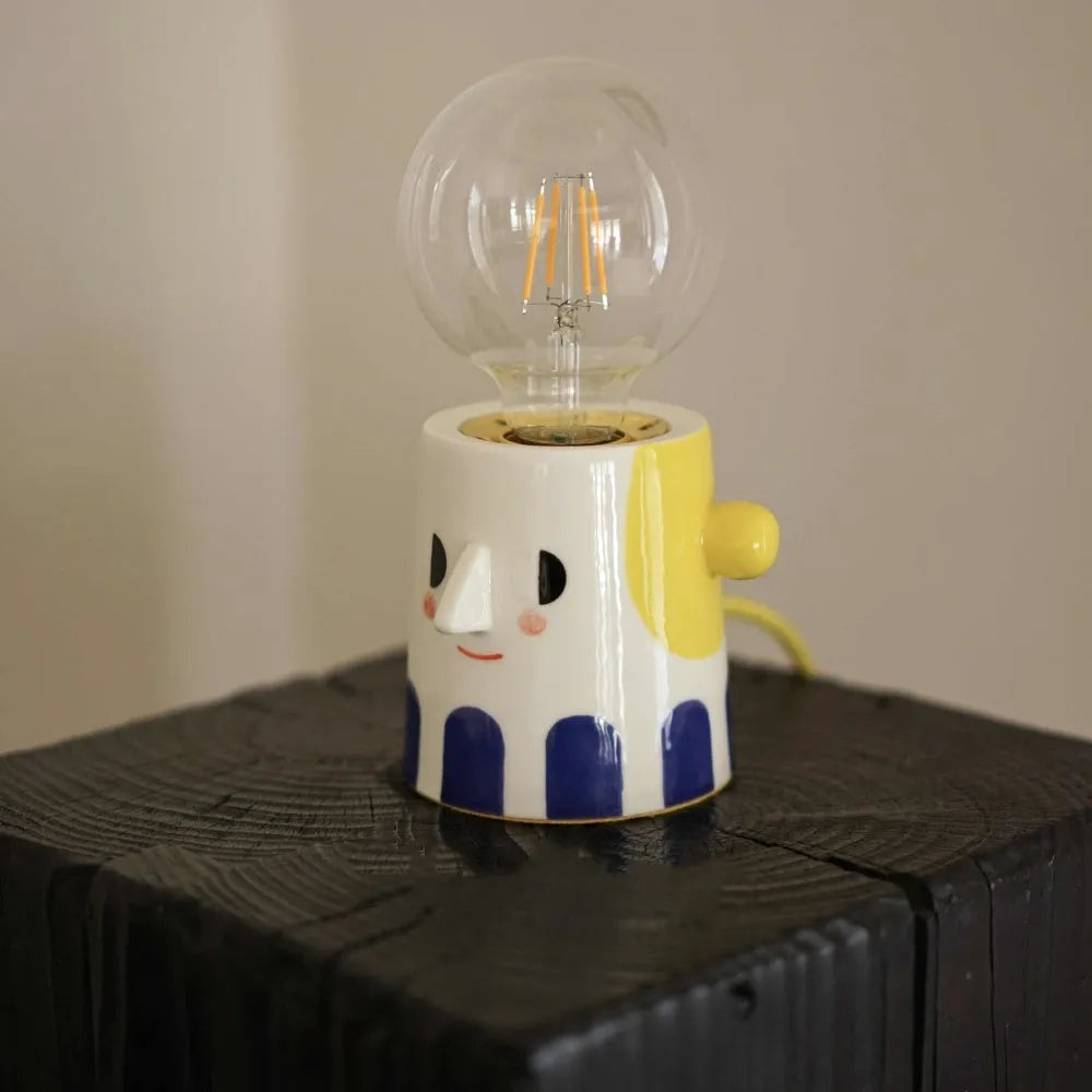 Handmade ceramic table lamp with ball headlight design on bedside table