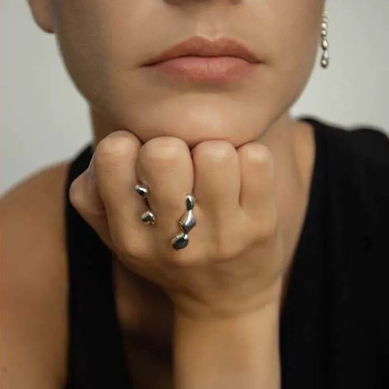 Brass opening ring with circle and sphere design in gold finish on finger