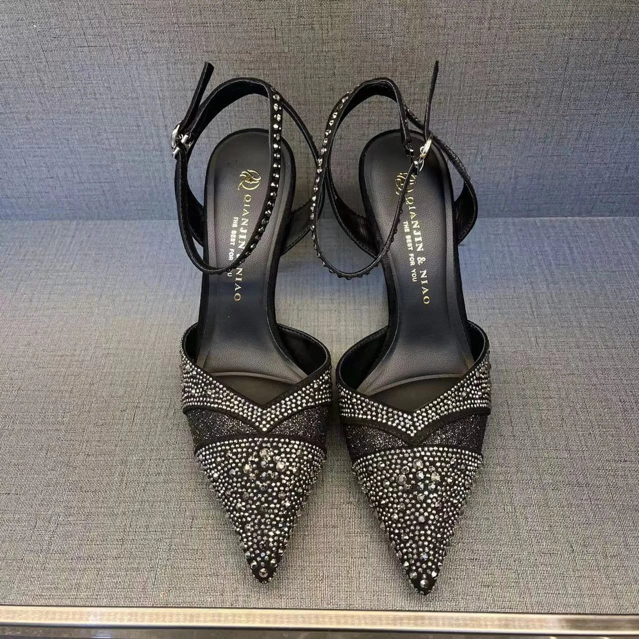 Women's black and silver hollow-cut stiletto high heels with pointed toes and red soles.