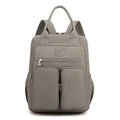 Women's large waterproof nylon travel backpack in lotus root purple showing internal laptop and camera compartments.