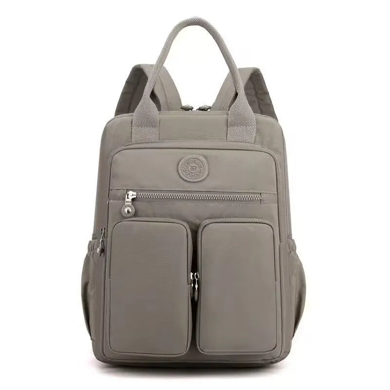 Women's large waterproof nylon travel backpack in lotus root purple showing internal laptop and camera compartments.