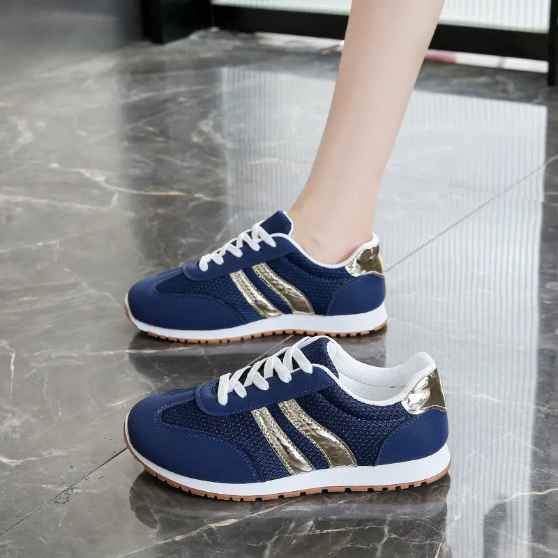 Blue women's casual tennis shoes with a cross shoulder strap and flat rubber sole on a white background.