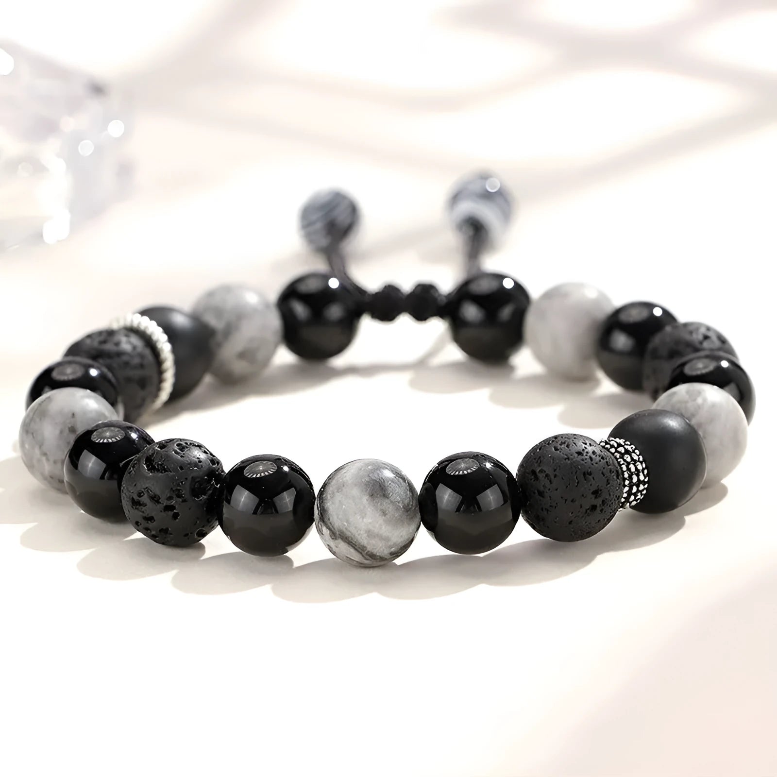 Black agate map stone diamond-shaped volcanic rock bracelet on a wrist, showing New Chinese style.