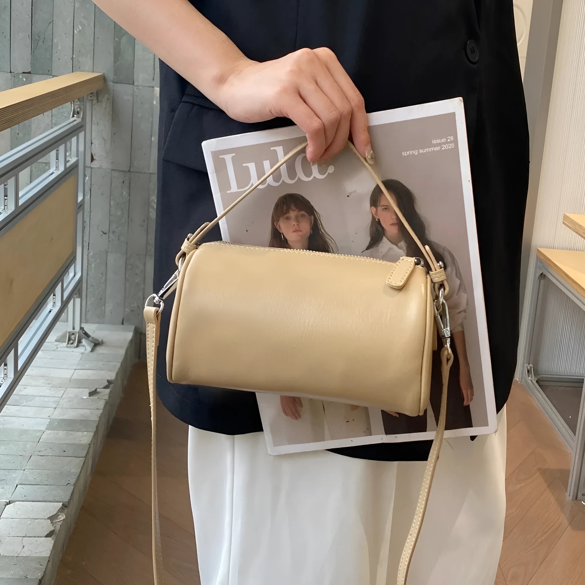 Genuine leather cylindrical crossbody bag for mobile phones in a street style, shown in brown.