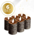 Four black LED pillar candles with flickering flame effect, shown grouped as a table centrepiece.