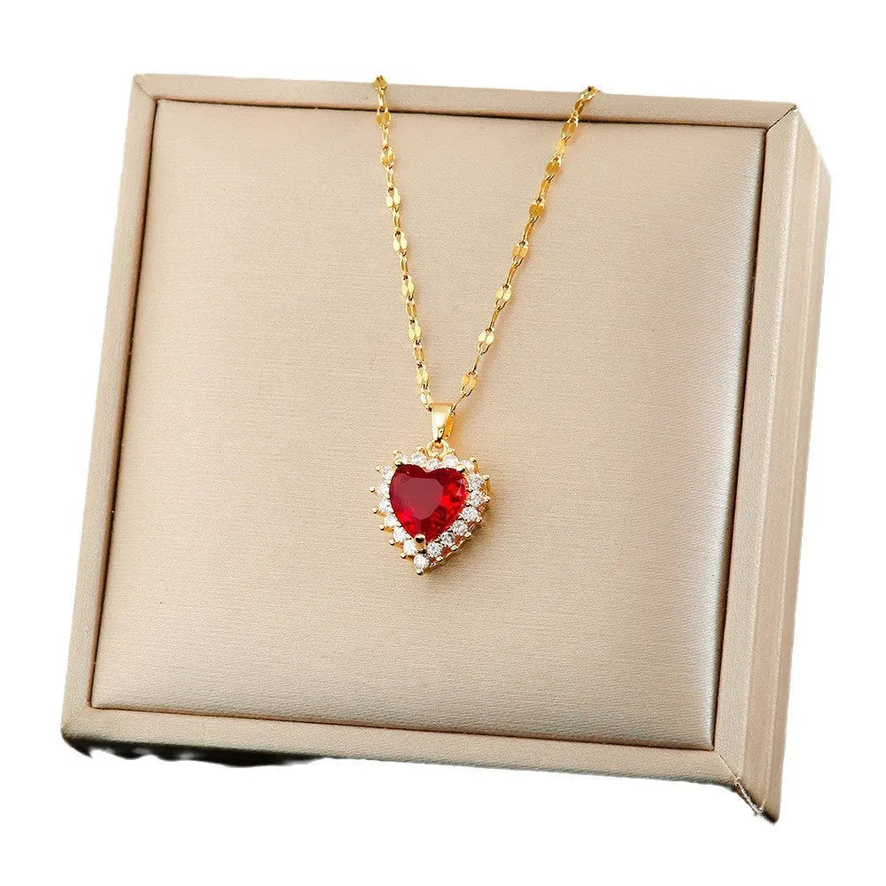 Gold and red titanium steel heart necklace set with mixed gem pendant, stud earrings and ring on white background