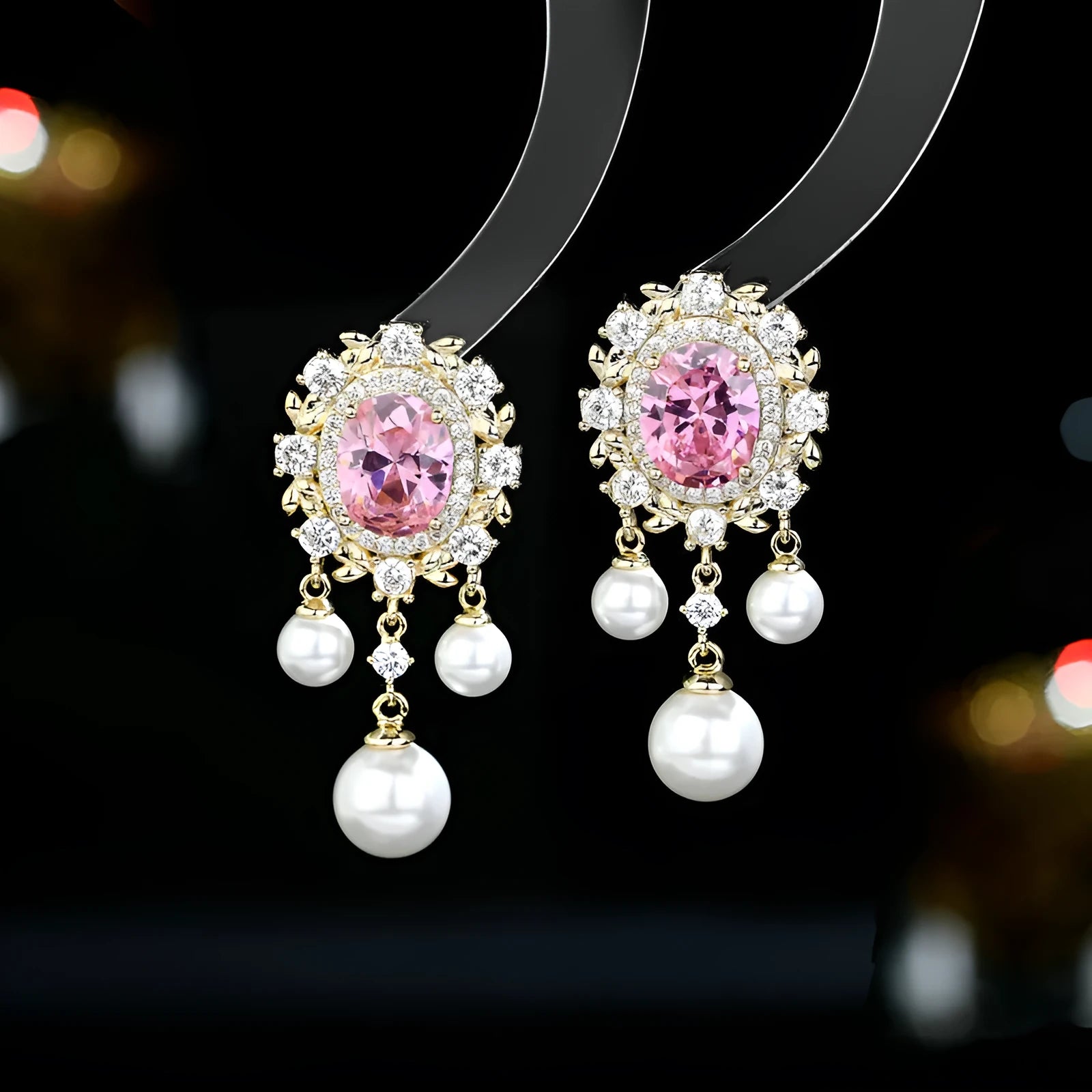 A pair of geometric ellipse-shaped drop earrings with a tassel, featuring pearls and inlaid zircon stones on copper.