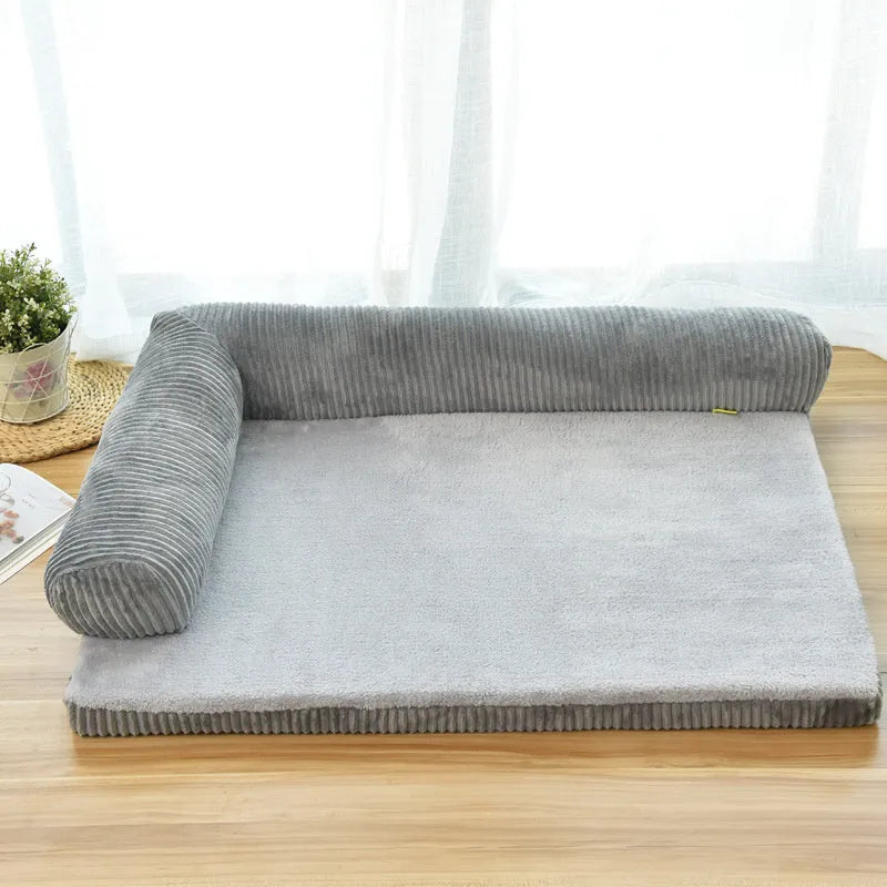 Corduroy dog sofa bed with bolster sides in a grey colour, shown on a wooden floor.