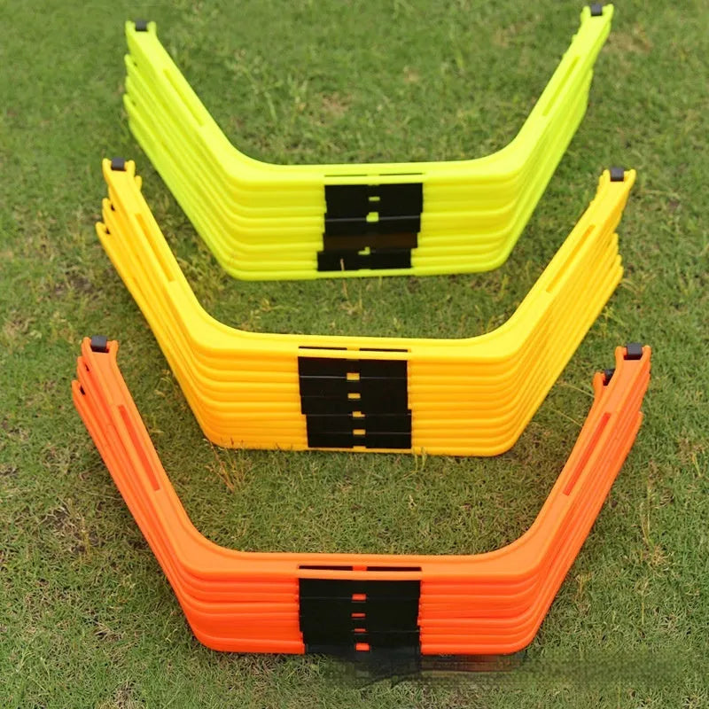 Six foldable hexagon football agility training rings in yellow, green, and orange colours laid out on grass.