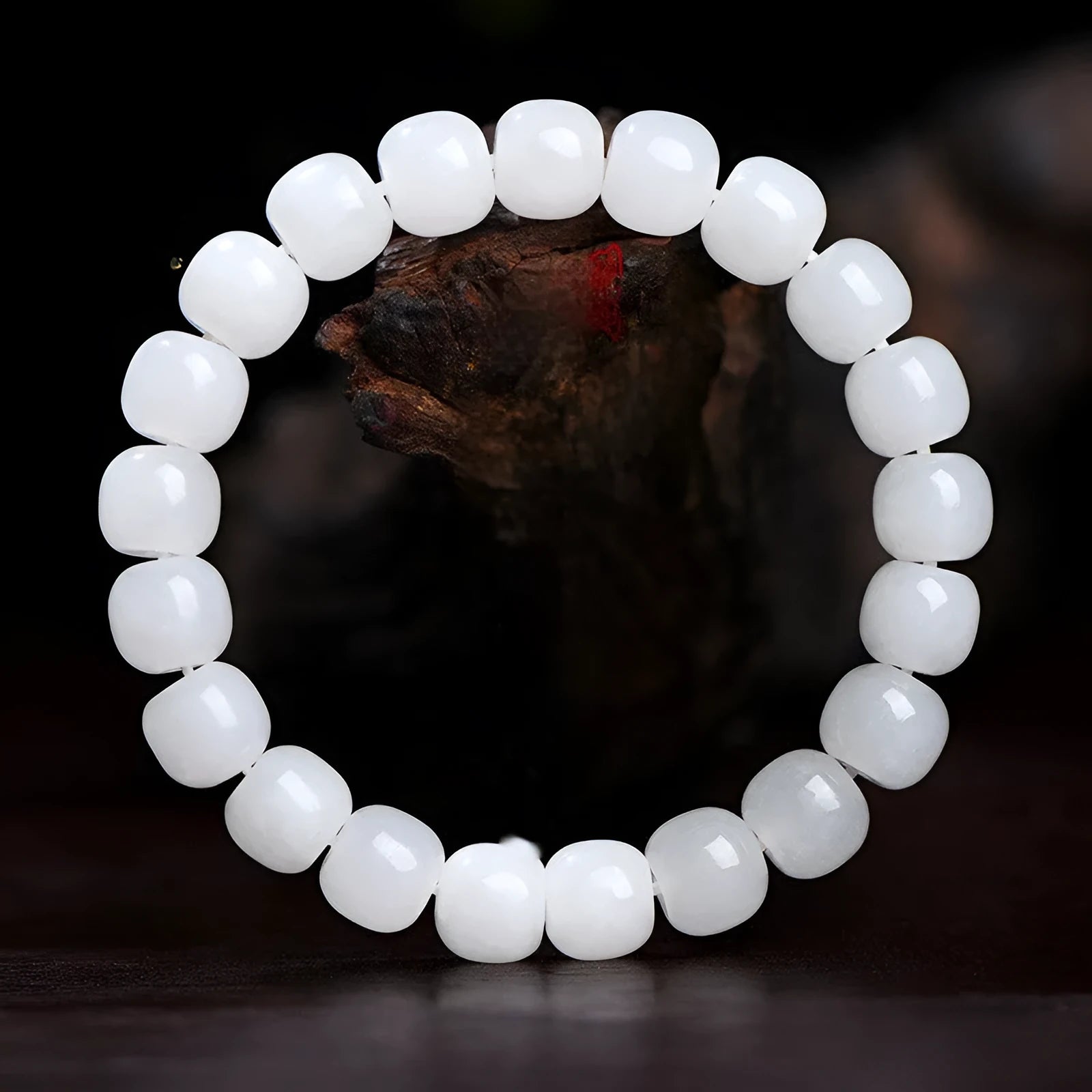 White Hetian jade barrel bead bracelet on a wrist, showing the traditional bead design.