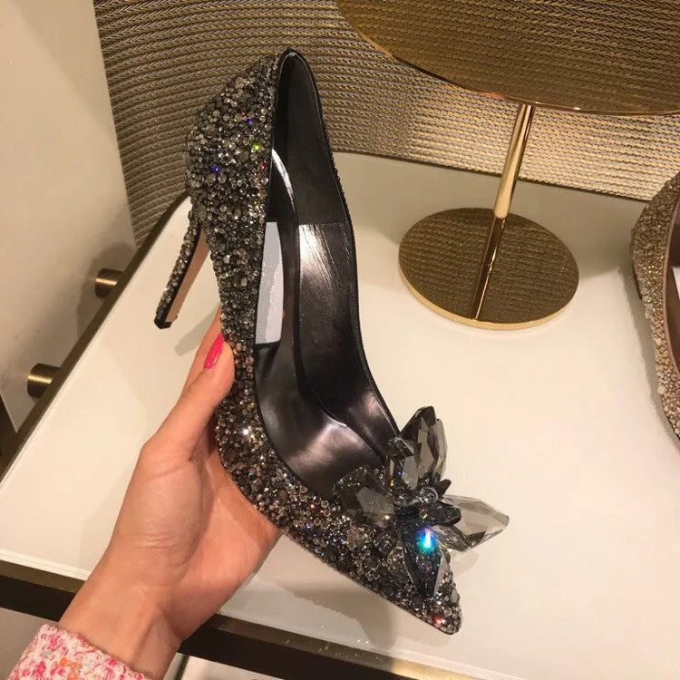Women's gold pointed toe stiletto heels decorated with rhinestones and a bow