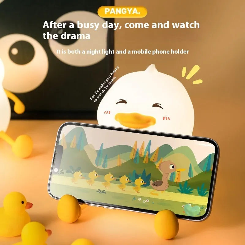 Chubby silicone rechargeable night light with phone holder on a desk