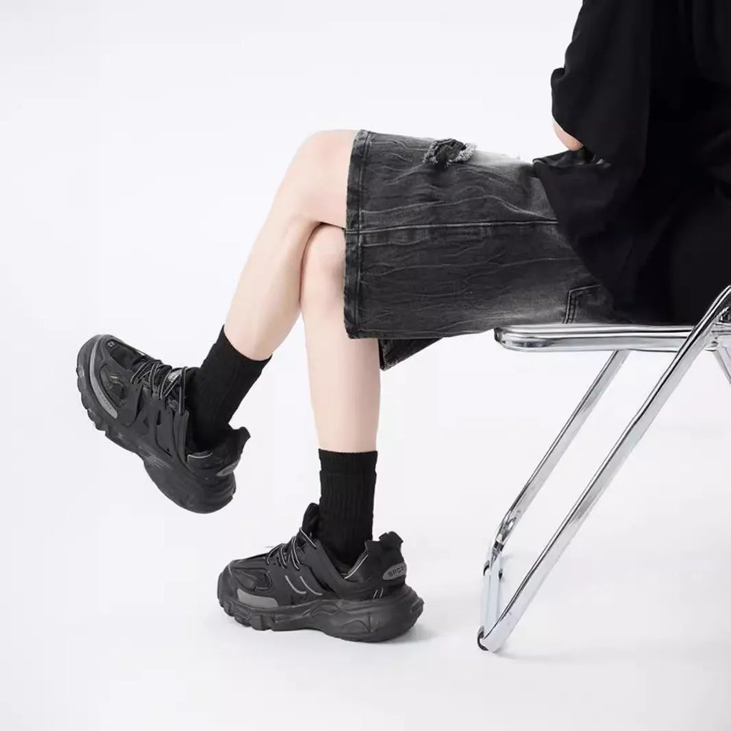 Loose-fit denim shorts with a washed fabric finish and ripped, distressed detailing on the legs.